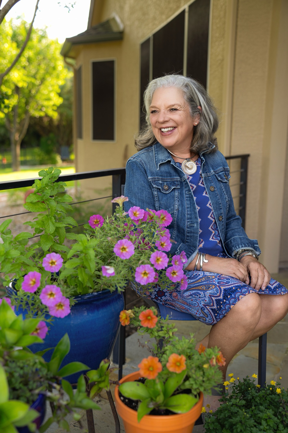 Laura outdoors in a sunlit garden, looking directly at the camera
