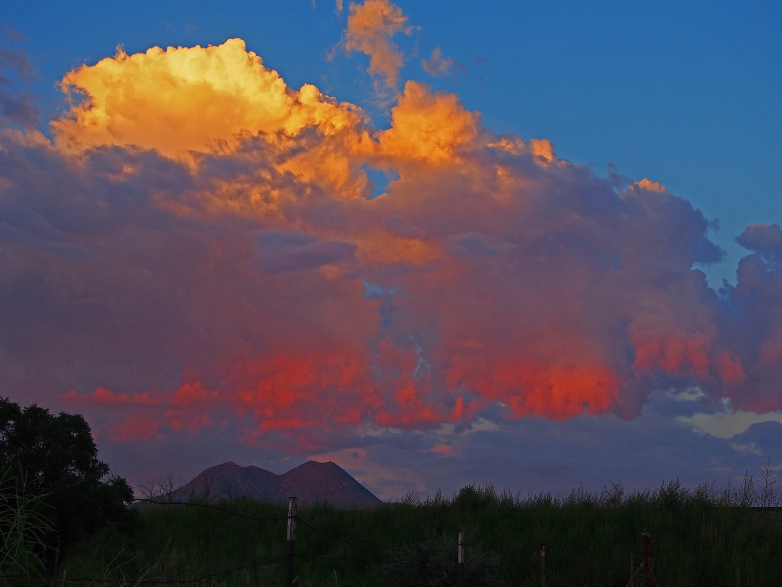 High afternoon clouds stacked over open country